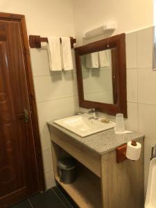 a bathroom with a sink and a mirror at Jey's Jiko Kitchen and Resort in Muhoroni