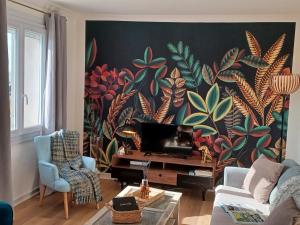 コンカルノーにあるappartement vue merの大きな花の壁画が壁に施されたリビングルーム