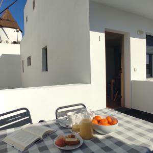 a table with a plate of fruit and a bowl of orange juice at Apartamentos LOS GATA GATA in Las Negras