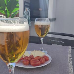 two glasses of beer and a plate of cheese and grapes at Apartamentos LOS GATA GATA in Las Negras