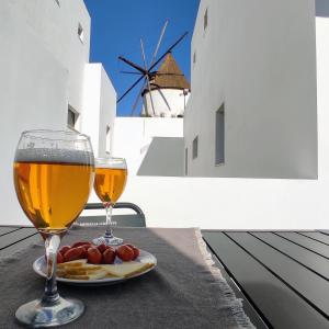 dos vasos de cerveza y un plato de comida en una mesa en Apartamentos LOS GATA GATA, en Las Negras