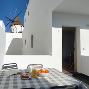 una mesa con un tazón de fruta y un molino de viento en Apartamentos LOS GATA GATA, en Las Negras