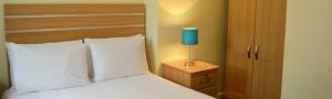 A bed or beds in a room at Horizon Hotel Apartments - Close to Beach, Train Station & Southend Airport