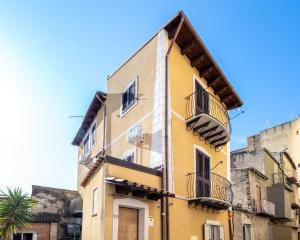 a yellow building with balconies on the side of it at Casa Vacanze A' Lanterna in Licata