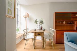 a dining room with a wooden table and chairs at The Broughton St. Apartment (1BR) - New Town in Edinburgh