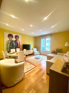 a living room with yellow walls and white furniture at Grand Plaza Mio Cid in Burgos
