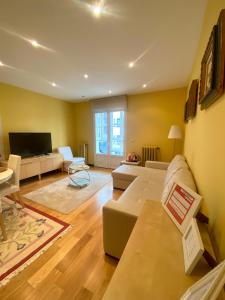 a living room with a couch and a tv at Grand Plaza Mio Cid in Burgos