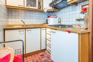 eine Küche mit weißen Schränken und einer Arbeitsplatte in der Unterkunft Le Marmotte del Brenta in Carisolo