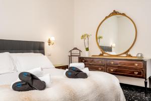 a bedroom with a bed with a mirror and two slippers at Appartamento A spasso nel tempo in Deiva Marina