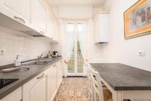 a kitchen with white cabinets and a black counter top at Appartamento A spasso nel tempo in Deiva Marina