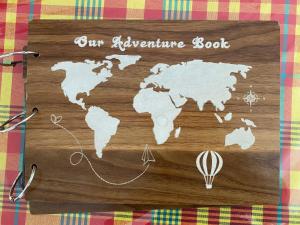 a wooden sign with a map of our adventure book at Le refuge privatif de Julie in Basse-Pointe