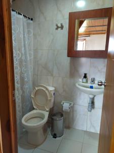 a bathroom with a toilet and a sink at Sol y Luna Villa Campestre in Iza