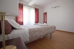 a bedroom with a bed with two towels on it at WATERS HOUSE - Feel at Home ir our Sea in Peniche