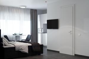 ein Schlafzimmer mit einem Bett und 2 Stühlen sowie eine Küche in der Unterkunft The Residences - Apartments Frankfurt in Offenbach