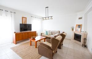 a living room with a couch and a tv at WATERS HOUSE - Feel at Home ir our Sea in Peniche