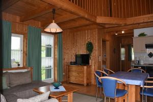 ein Wohnzimmer mit einem Tisch und einer Küche in der Unterkunft Ferienhaus Nr 13A2, Feriendorf Hagbügerl, Bayr Wald in Waldmünchen