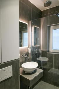 une salle de bain avec un lavabo et un miroir dans l'établissement Modern Gelijkvloers Gezinsappartement, à Knokke-Heist