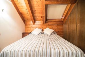 1 dormitorio con 1 cama con techo de madera en Bonic d´Àneu, en Esterri d'Àneu