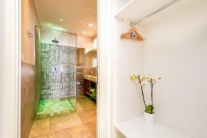 a bathroom with a shower and a vase of flowers at Camera Carolina in Deiva Marina