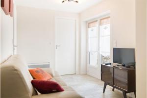 a living room with a couch and a television at Belle location Spa et grande terrasse privés in La Couarde-sur-Mer