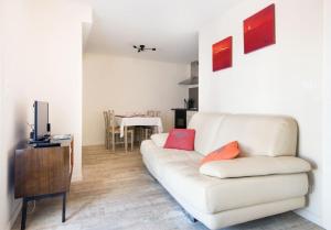 a living room with a white couch and a table at Belle location Spa et grande terrasse privés in La Couarde-sur-Mer