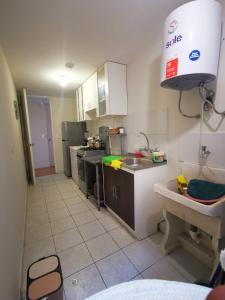 a kitchen with a sink and a counter top at Departamento amoblado en condominio - 5to piso in Tacna