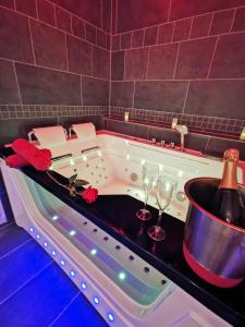 a bath tub with wine glasses and a bottle of champagne at Aux Bulles in Limoges