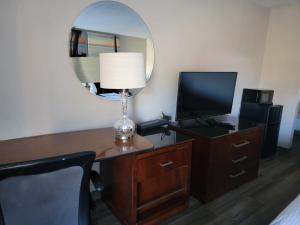 a room with a desk with a lamp and a mirror at Executive Inn & Suites in Dothan