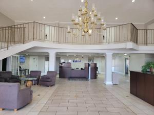 a large lobby with chairs and a chandelier at Executive Inn & Suites in Dothan +31 photos