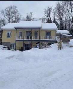 una casa con nieve encima de un montón de nieve en Hébergement La Belle Époque en Saint Come