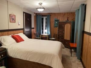 ein Schlafzimmer mit einem großen Bett und einer Kommode in der Unterkunft Hébergement La Belle Époque in Saint Come