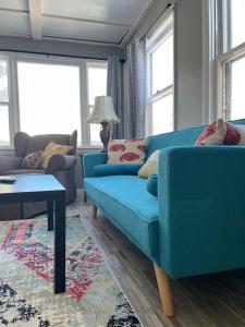 a living room with a blue couch and a table at Rustic 2 Bedroom Boho Apartment in Laramie