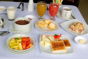 una mesa blanca con platos de comida y bebida en Hotel Virrey Central, en Bogotá