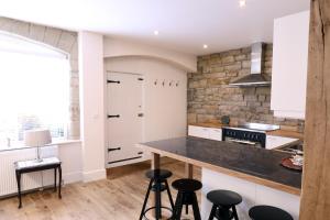 a kitchen with a counter and stools in it at Stable Cottage in Pateley Bridge