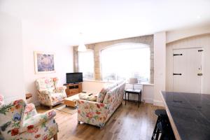 a living room with two chairs and a television at Stable Cottage in Pateley Bridge