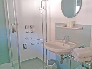 a bathroom with a sink and a shower with a mirror at Ferienwohnung Danner in Kiefersfelden