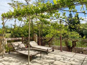 2 chaises sur une terrasse avec une balançoire dans l'établissement Mas Bourdaric - Location de Gites en Ardeche du Sud, à Saint-André-de-Cruzières