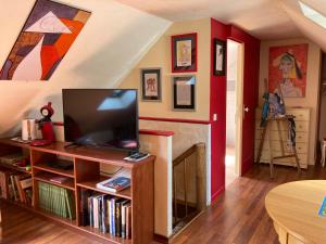 a living room with a television on a book shelf at Moulin des Baleines de Kérandraon Plouguerneau in Plouguerneau