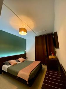 カレーにあるCitadel Hôtelのベッドルーム1室(緑のヘッドボード付きのベッド1台付)