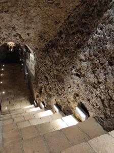un tunnel en pierre avec des lumières sur le côté d'un mur dans l'établissement Le vigne sull’Adda, à Bottanuco