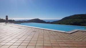 a large swimming pool with a view of the ocean at B&B A Robba de Pupi in Agrigento