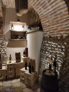 a wine tasting room with bottles of wine on boxes at Le vigne sull’Adda in Bottanuco