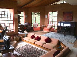 uma sala de estar com um sofá e um piano em Casa aconchegante na montanha à 15min do centro! em Campos do Jordão