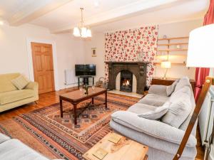 a living room with two couches and a fireplace at The Grotto in Kirkby Stephen