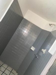 y baño con ducha de azulejos grises. en Hotel Oseguera, en Uruapan del Progreso