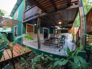 a patio of a house with a wooden deck at The Green Jungle & Tree House Caribe in Puerto Viejo