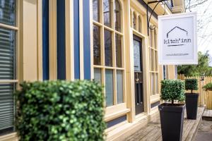 马洪贝The Kitch'inn - Boutique Inn and Wine Bar的一栋前面有招牌的建筑物
