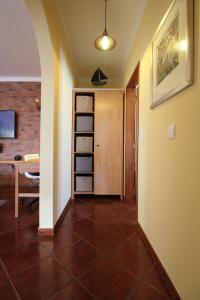 einen Flur mit einem Zimmer mit einem Tisch und einem Regal in der Unterkunft Apartamento Magnólia 80186 AL in Vila Nova de Milfontes + 18 Fotos