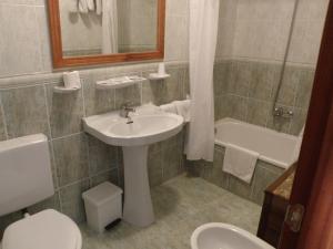 a bathroom with a sink and a toilet and a tub at Hotel restaurante Felipe II in Ayna