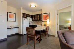 a kitchen and living room with a table and chairs at Sonesta ES Suites Anaheim Resort Area in Anaheim